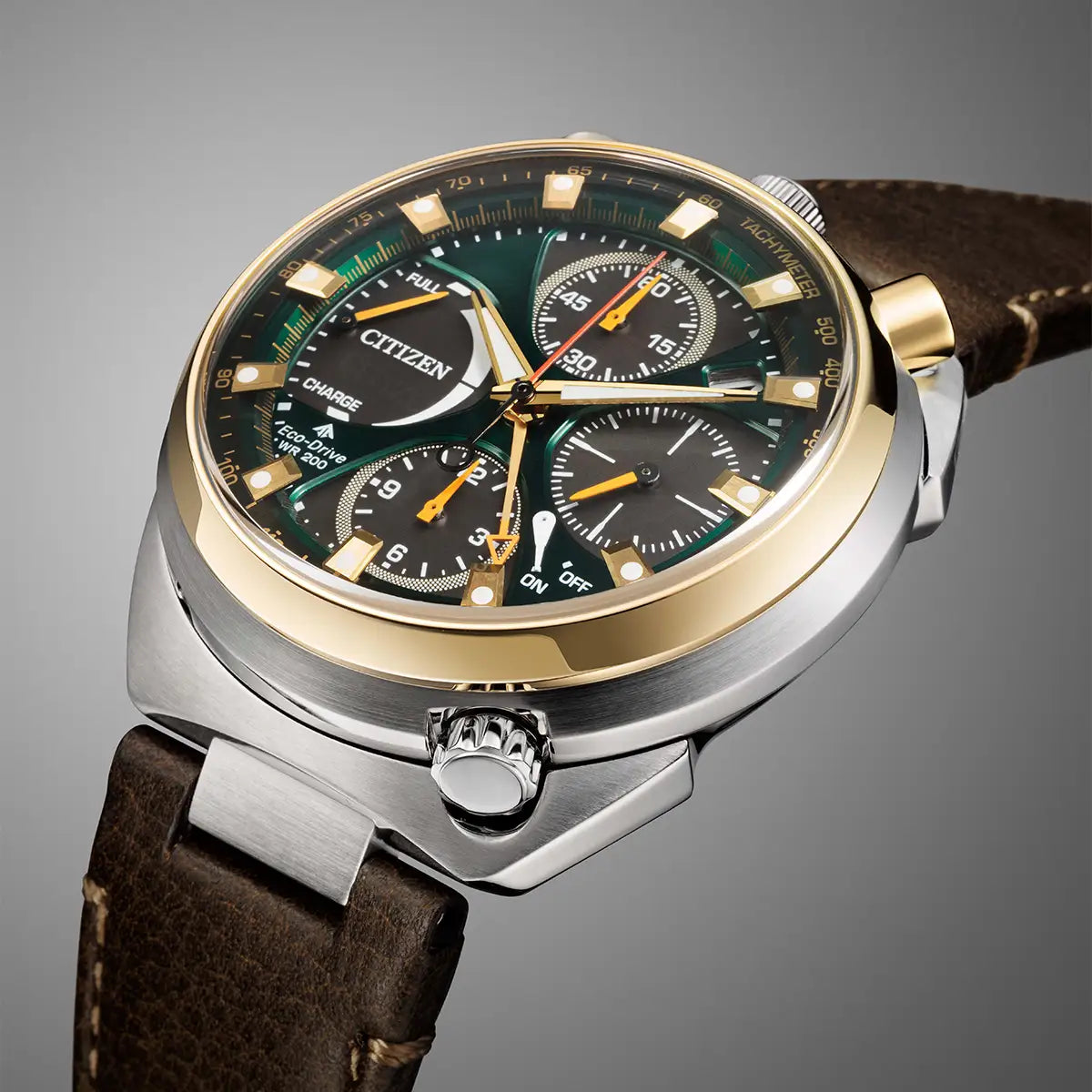 Citizen stainless steel chronograph watch with a green dial, gold-tone bezel and case accents, and a brown leather strap on a gray gradient background.