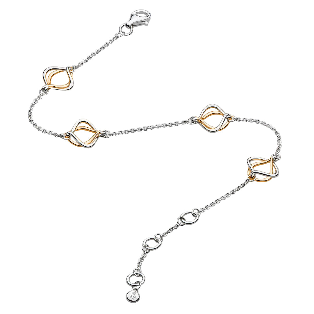 A delicate silver chain anklet featuring four interlocking double-loop heart-shaped charms in a two-tone gold and silver finish, displayed on a light gray background.