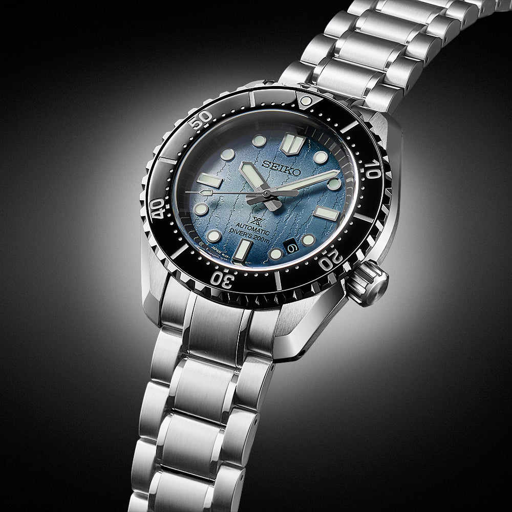 Silver Seiko watch with blue face on a dark background